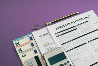 Finance application form; invoice; euro banknotes; calculator; and pencil arranged on purple surface for tech-business con...